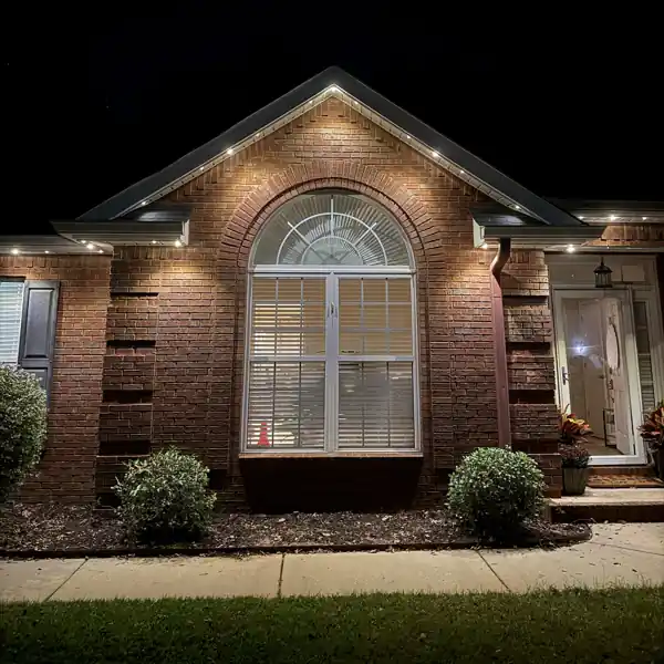 Permanent lighting along a gable peak above an arched window